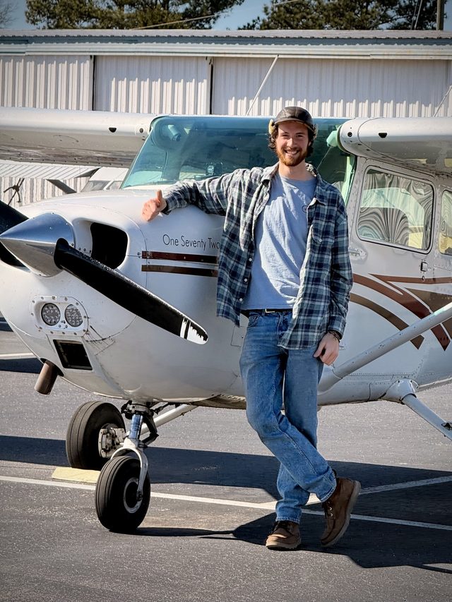Nate standing in front of a Cessna 172 ("One Seventy Two") on the ramp, giving a thumbs up after a training flight